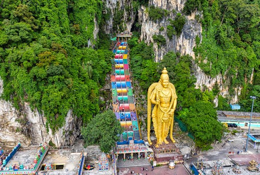 Aerial view of the vibrant Batu Caves and Lord Murugan statue in Selangor, Malaysia.