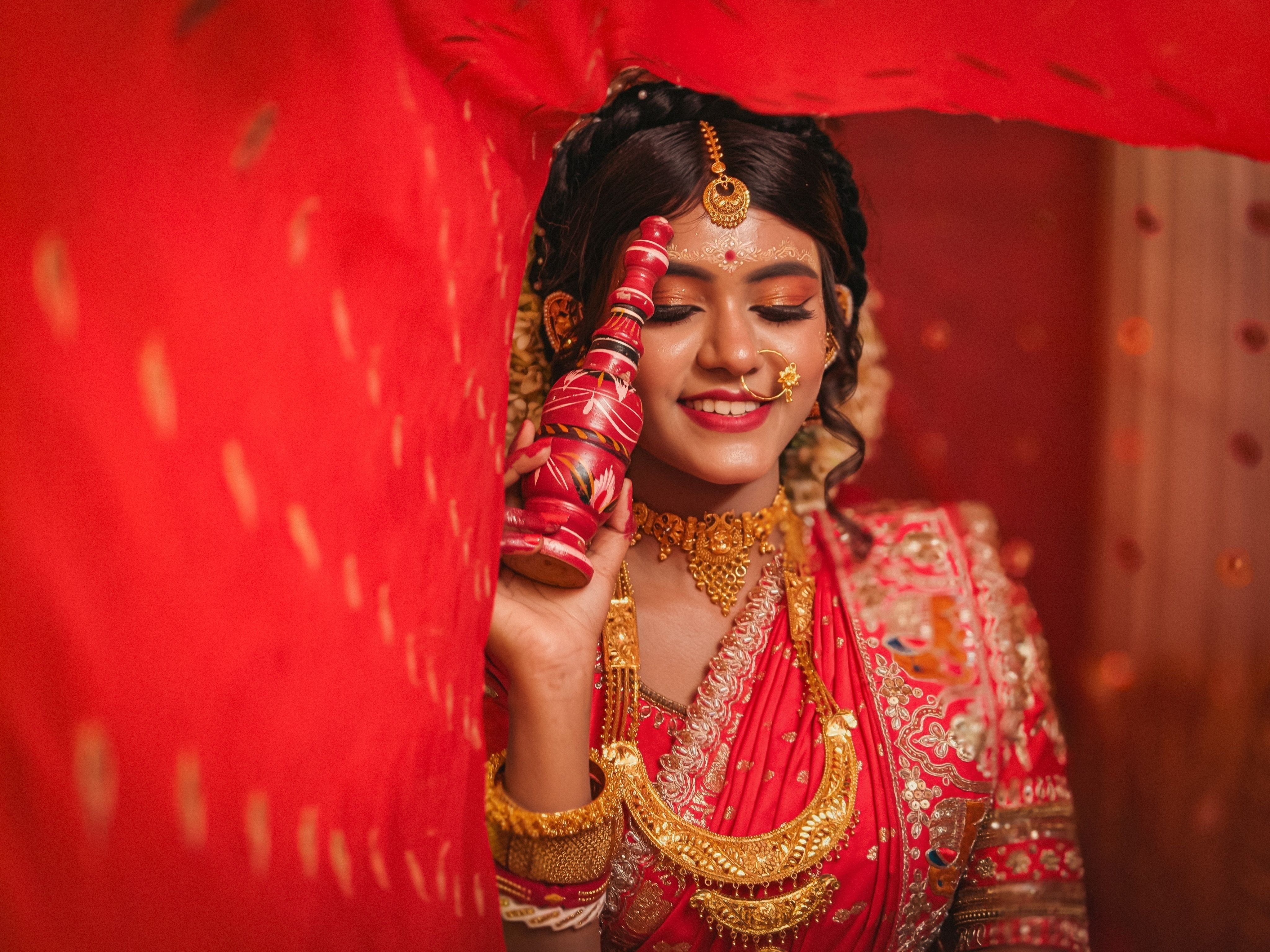 Stunning portrait of an Indian bride in red saree with traditional jewelry, Kolkata.