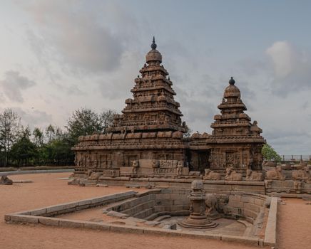 A captivating view of the historic Shore Temple in Mahabalipuram, Tamil Nadu, India, with a serene sky backdrop.