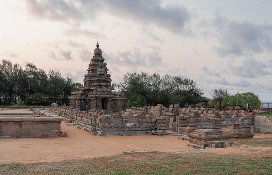Historic Shore Temple at Mahabalipuram during sunset, showcasing intricate stone carvings and architecture.