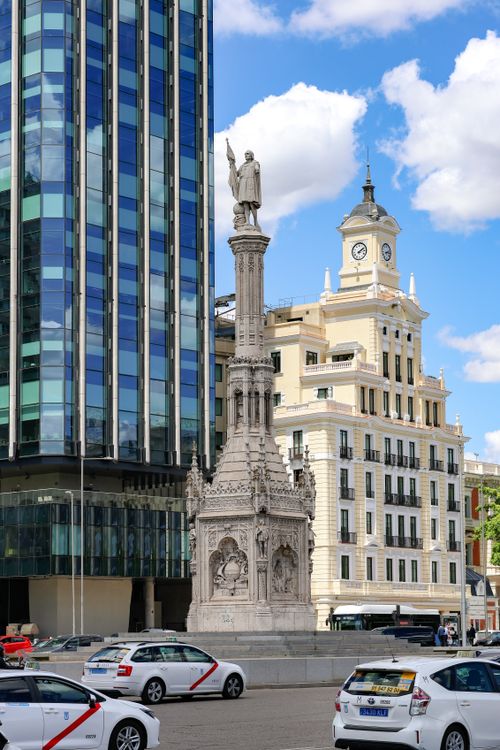 Free Columbus statue in Madrid with modern and classic architecture in the background. Stock Photo