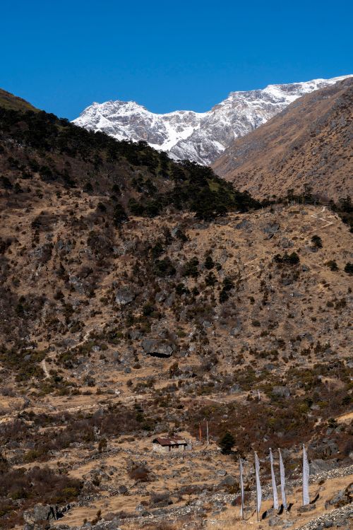 Free Scenic view of rugged mountains with snow-capped peaks under a clear blue sky. Stock Photo