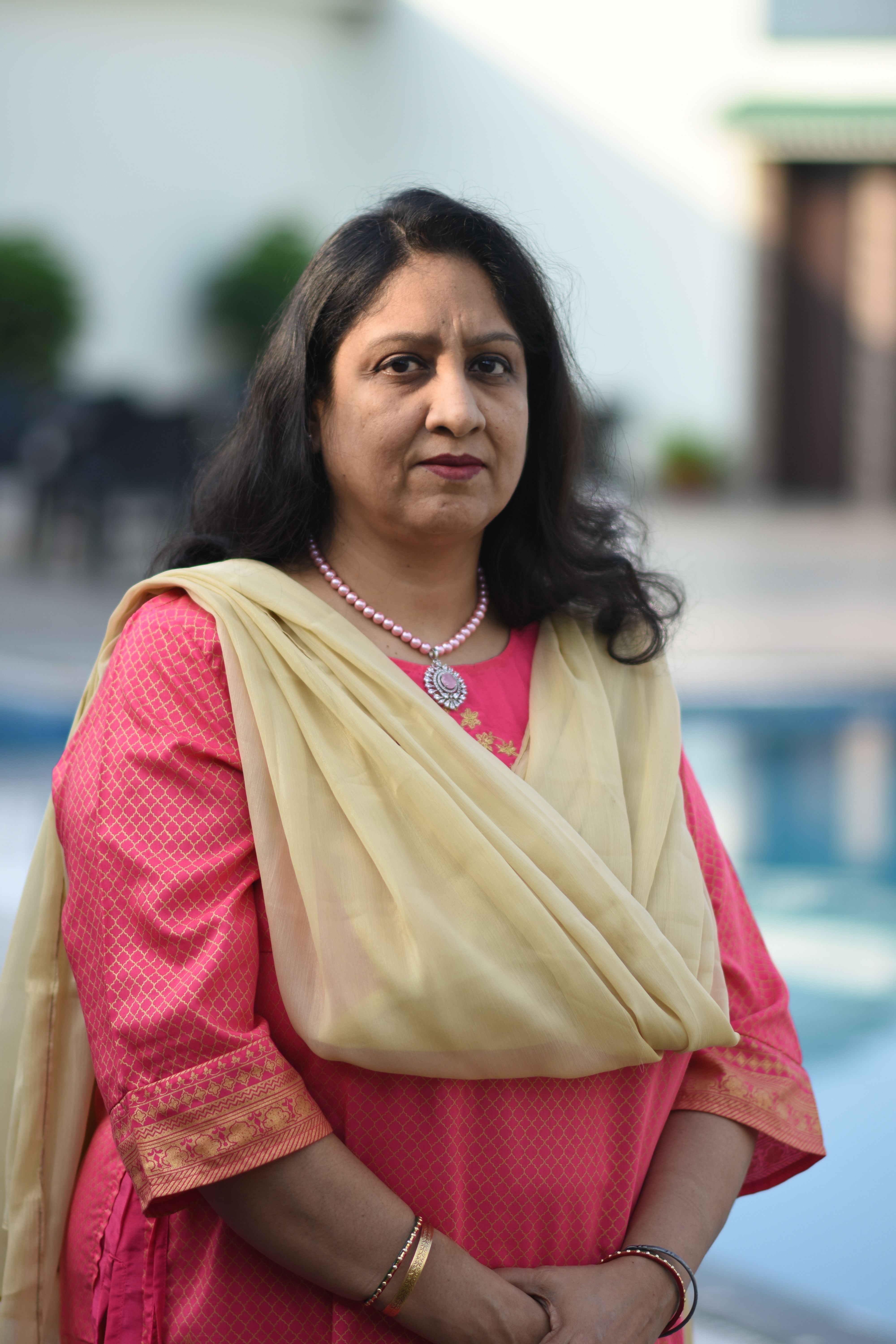 Portrait of a woman in traditional Indian clothing by a poolside in Ballavpur, India.