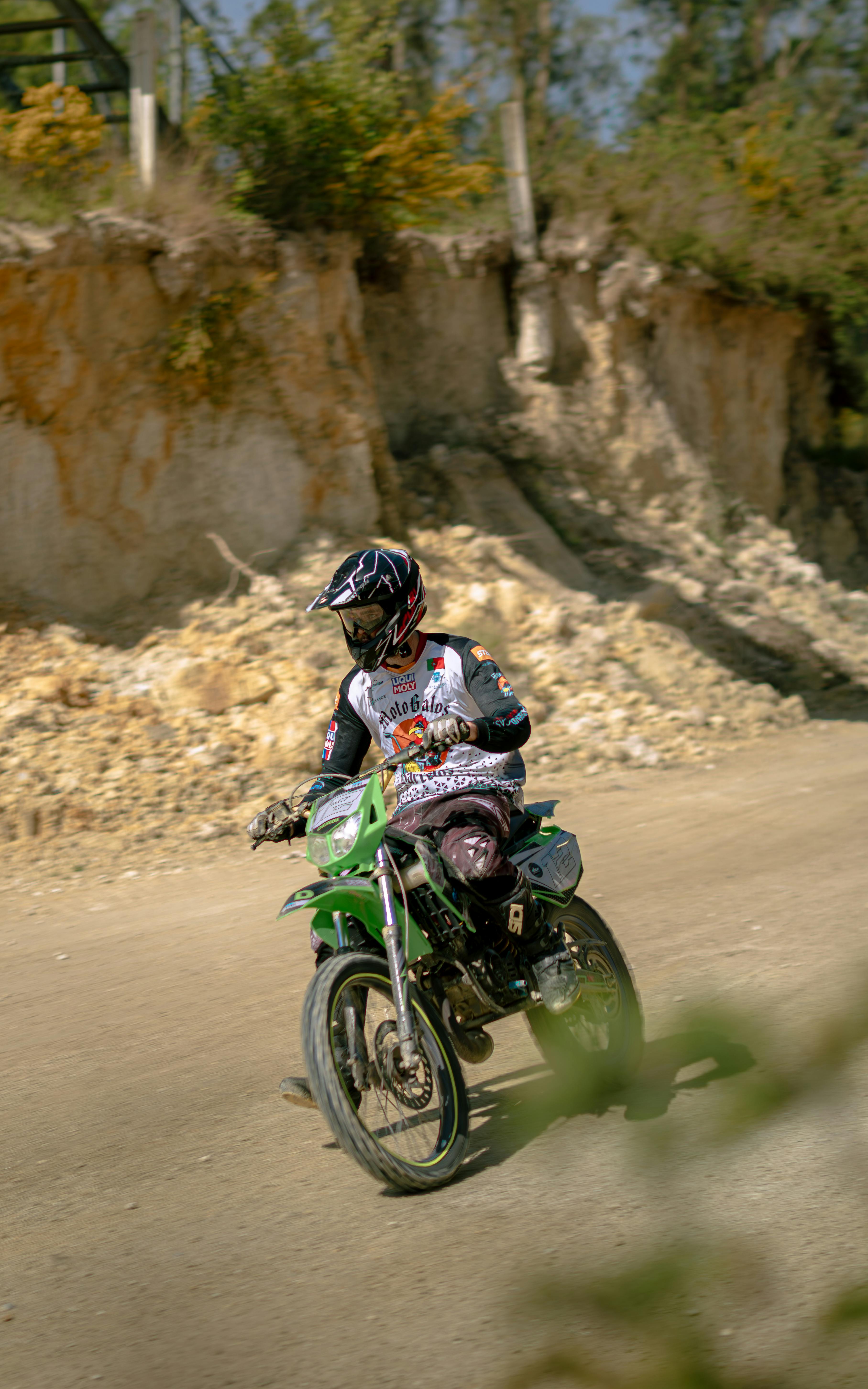 A motorcyclist wearing gear races through a rugged off-road terrain, showcasing adventure and thrill.