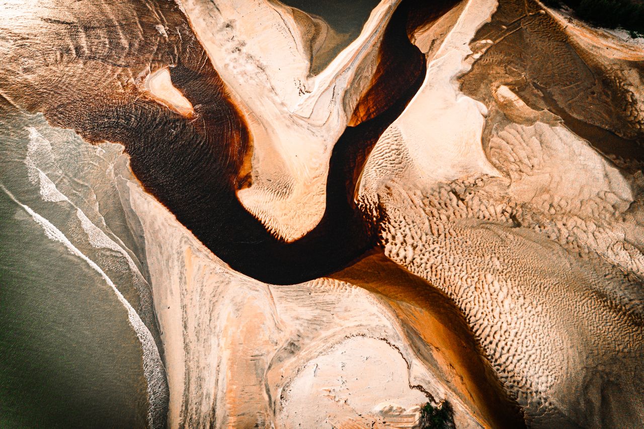 a stunning aerial view showcasing intricate sand patterns and a windin