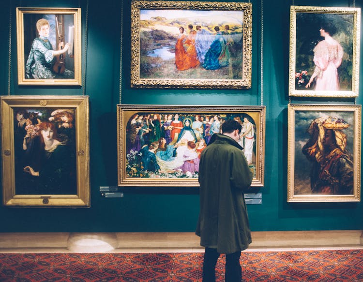 Man Standing In Front Of Paintings