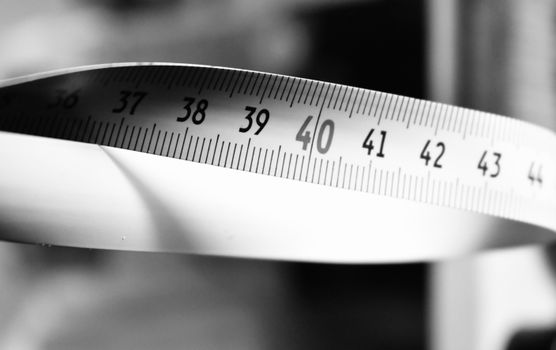 Artistic black and white photo of a measuring tape showing numbers 36-44.