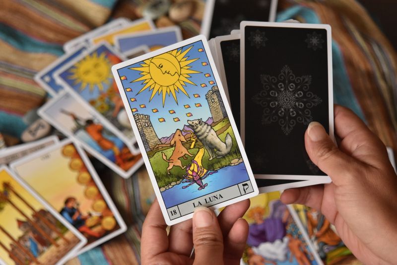 Close-up of hands holding tarot cards for fortune telling.
