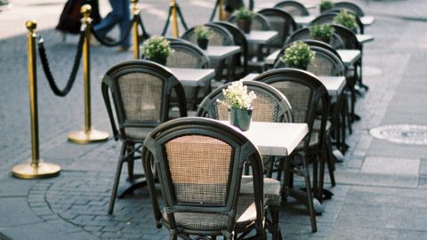 Charming outdoor cafe seating on a cobblestone city street, perfect for al fresco dining.