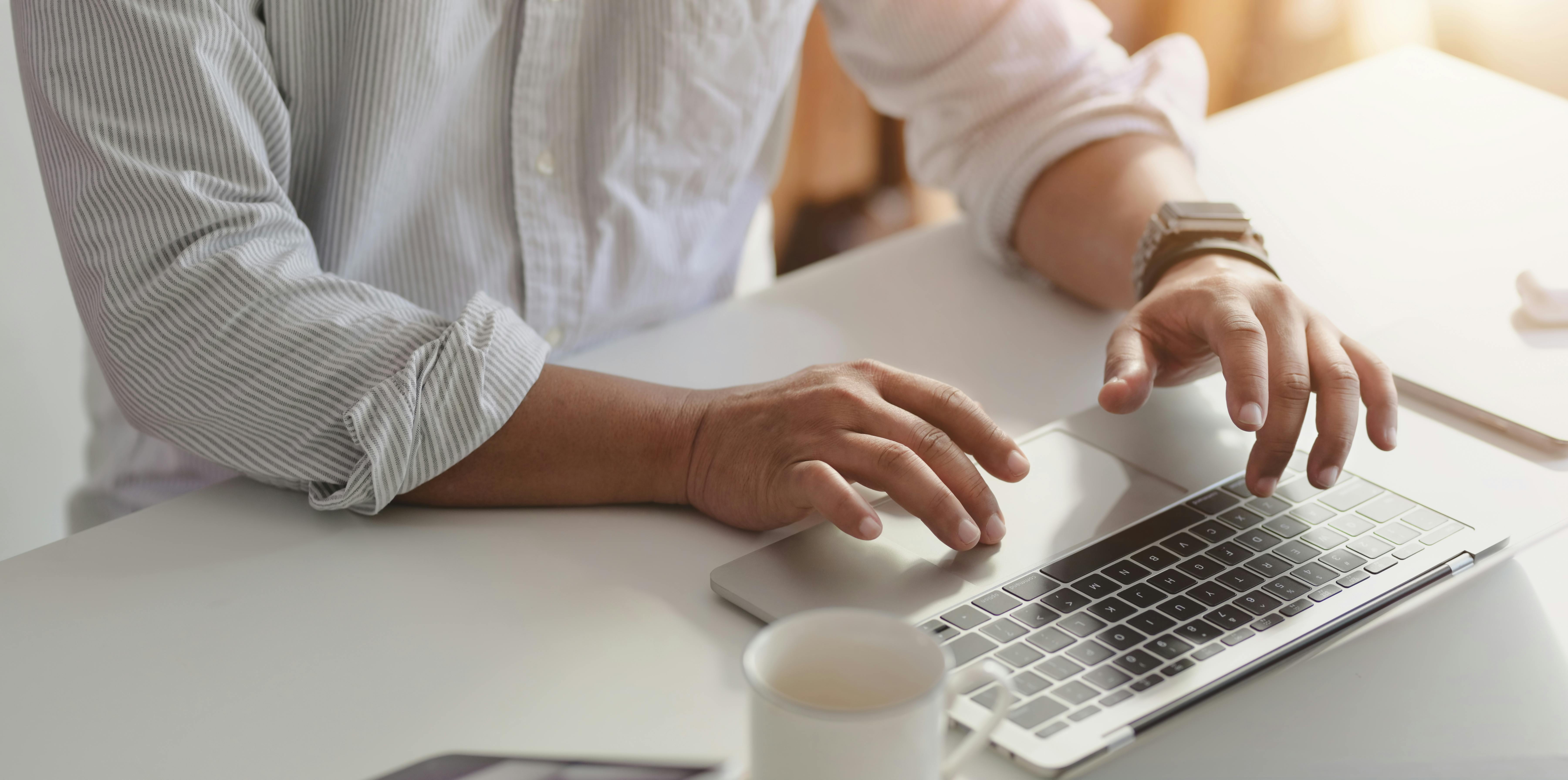 Person in White Dress Shirt Using Macbook Pro