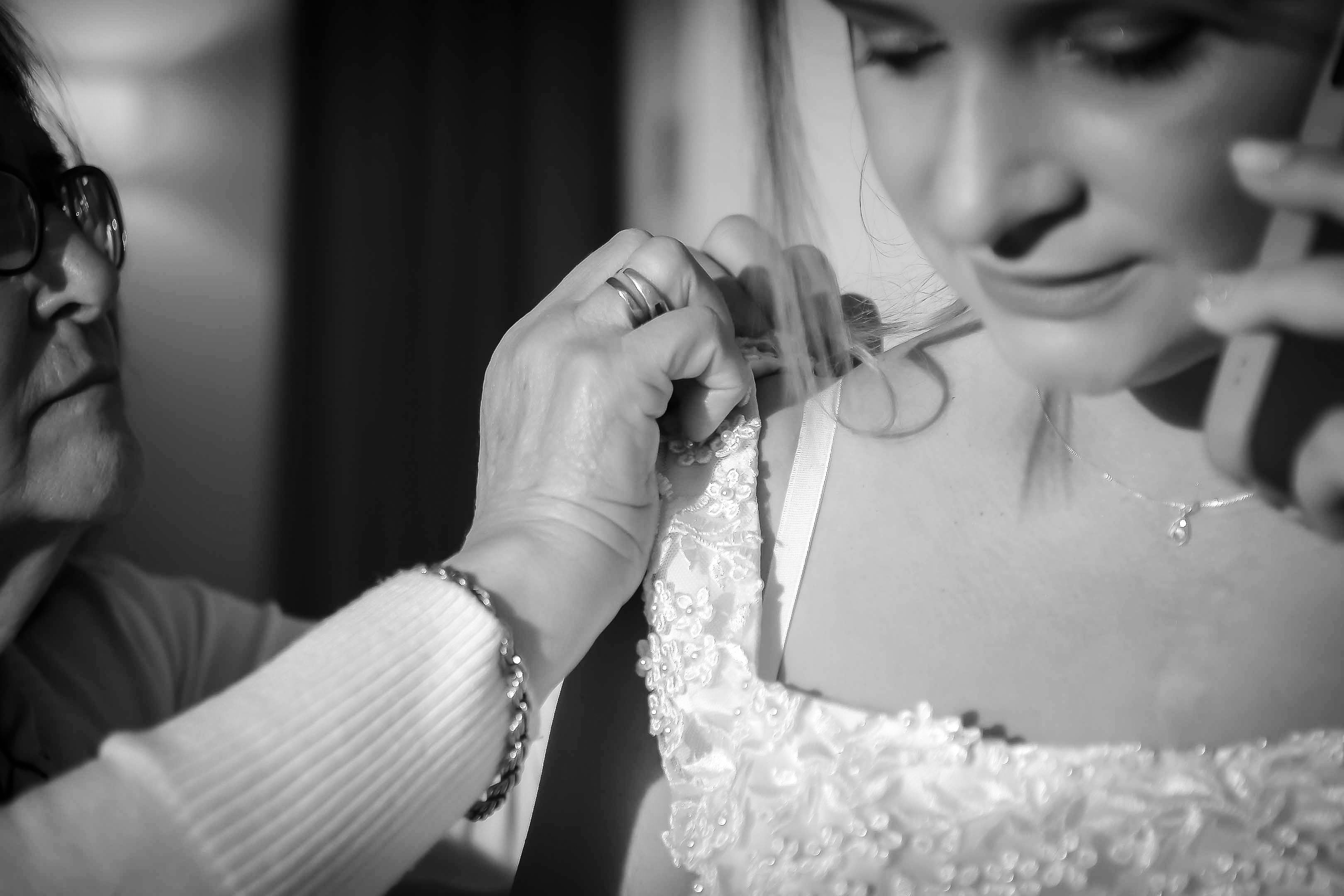 Elegant moment of a bride getting ready for her wedding, captured in black and white.