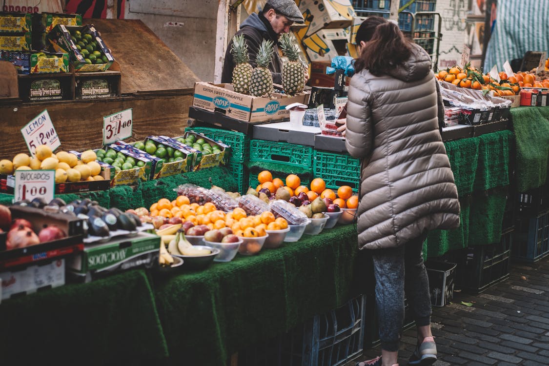 Woman Standing in Front of Assorted Fruits Displayed