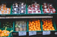 当地市场的摊位上，摆放着色彩缤纷的新鲜水果，上面贴着价格标签