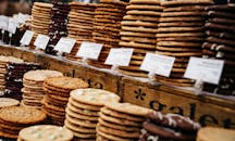 繁忙的市场摊位上，各种饼干被优雅地堆放并贴上标签