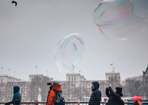無料 空中に浮かぶ泡の写真を撮る人 写真素材