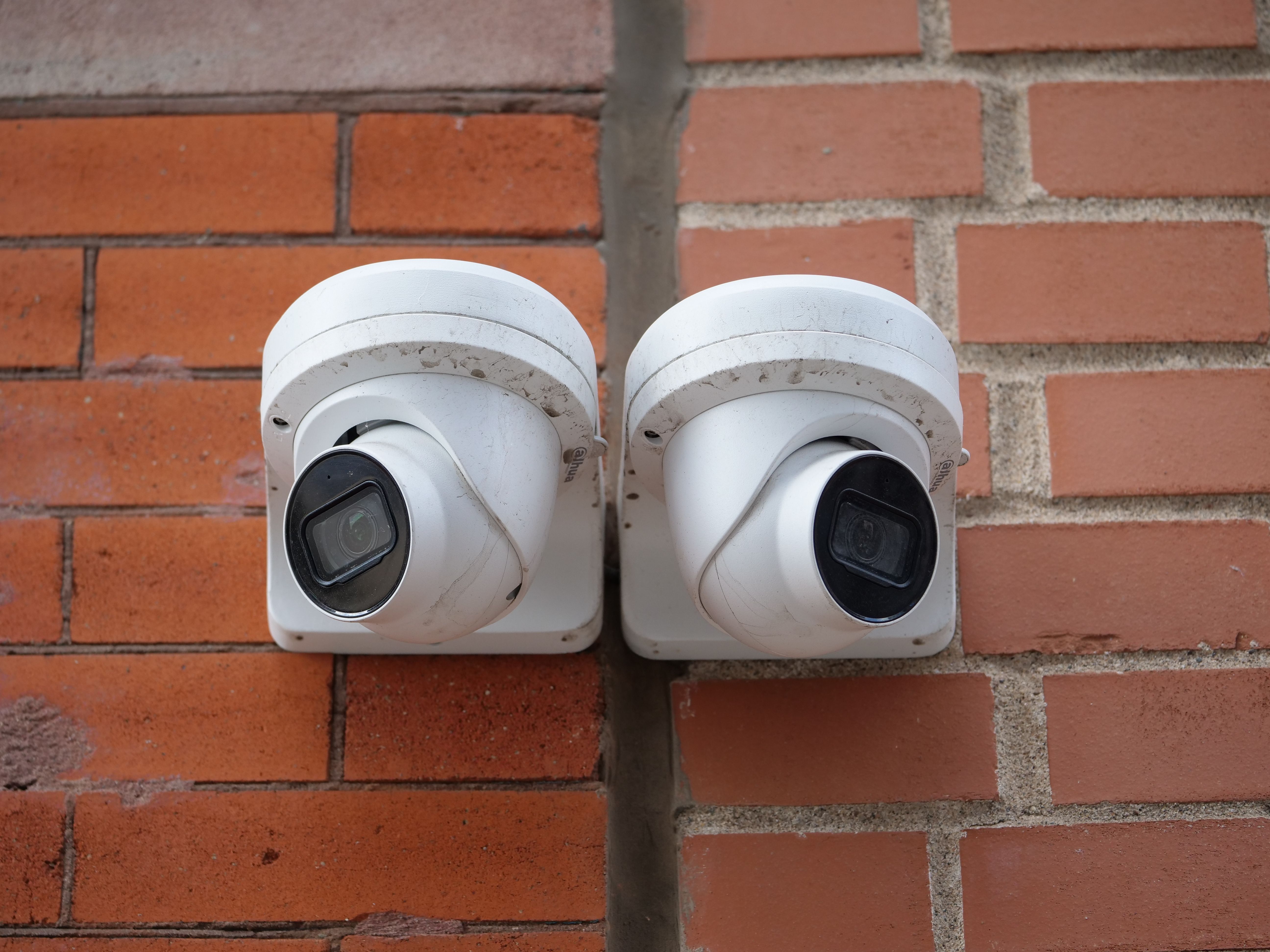 Dual Security Cameras on Brick Wall for Surveillance · Free Stock Photo