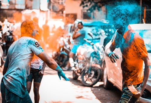 Joyful people throwing colored powders while celebrating Holi festival