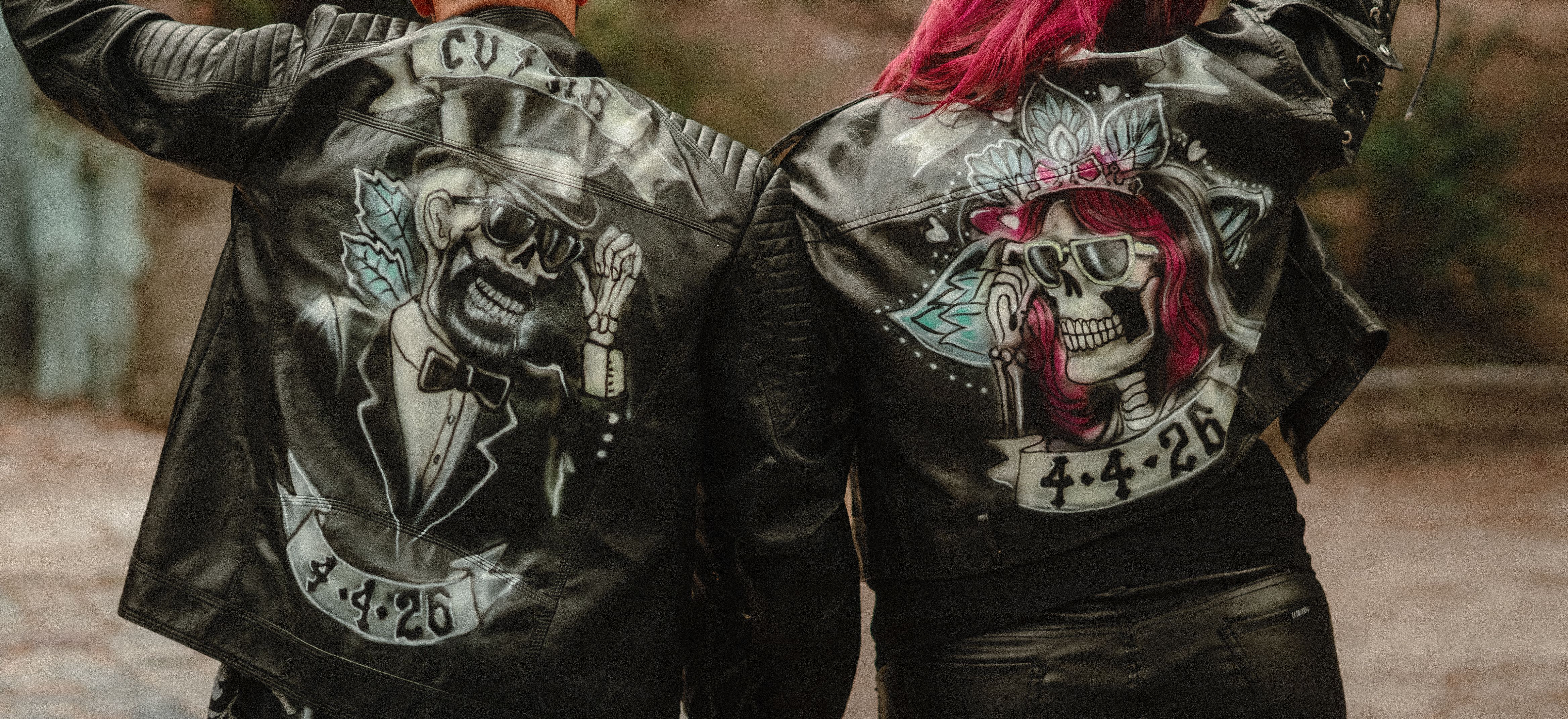 Two people wearing custom leather jackets featuring skeleton artwork and unique design elements.