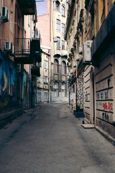 Charming narrow street with graffiti and historic architecture in Lviv.