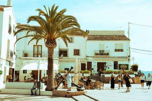 Free Vibrant town square in Altea, Spain, with palm trees and lively visitors enjoying a sunny day. Stock Photo