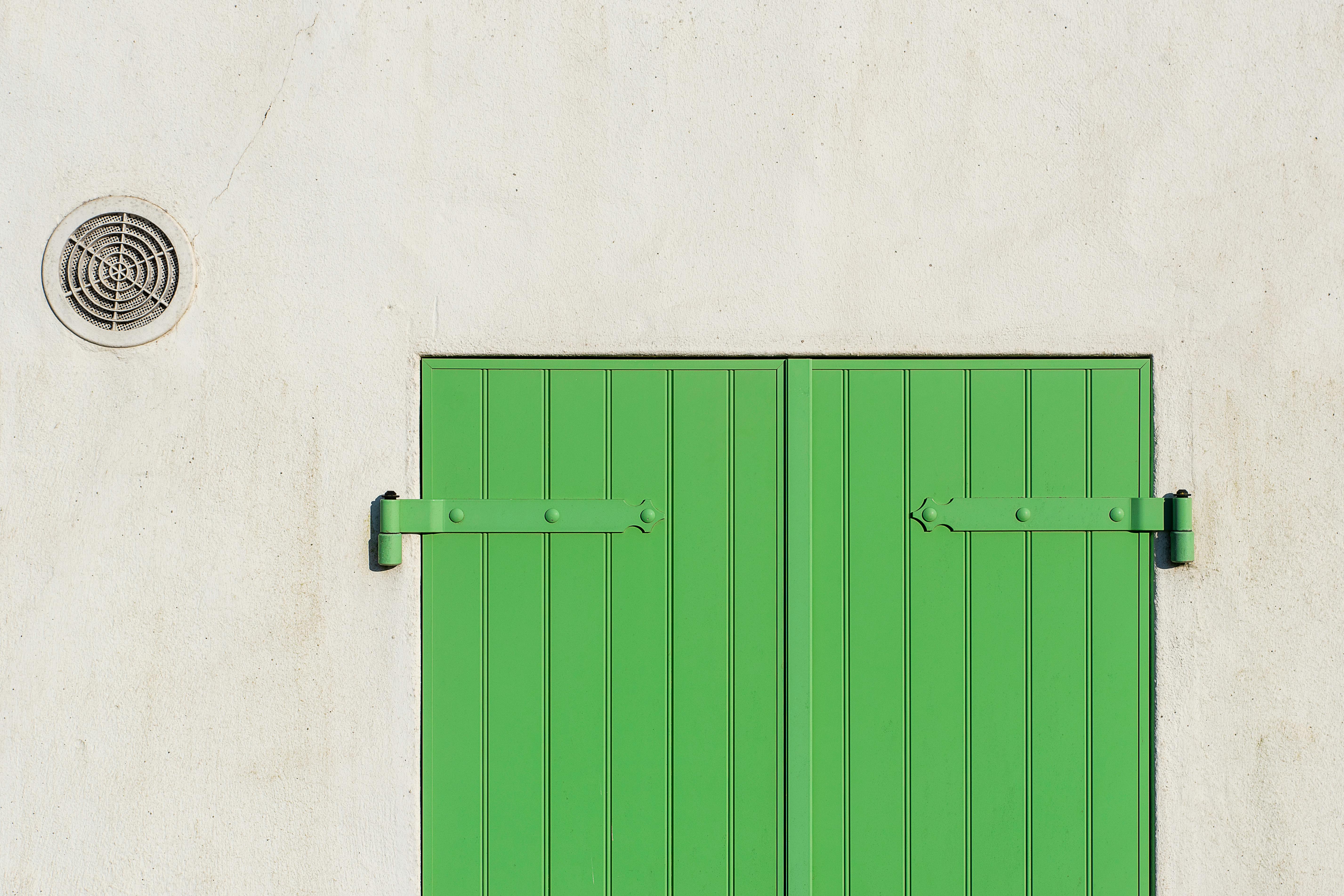 Modernes Schlafzimmer mit dezentralem Wandlüfter nahe dem Fenster, ruhige helle Wand und reduzierte Einrichtung