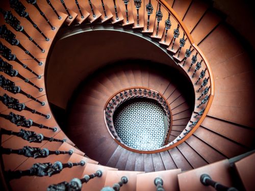 Free Elegant spiral staircase with intricate railing in Wrocław, Poland. Captured from above. Stock Photo