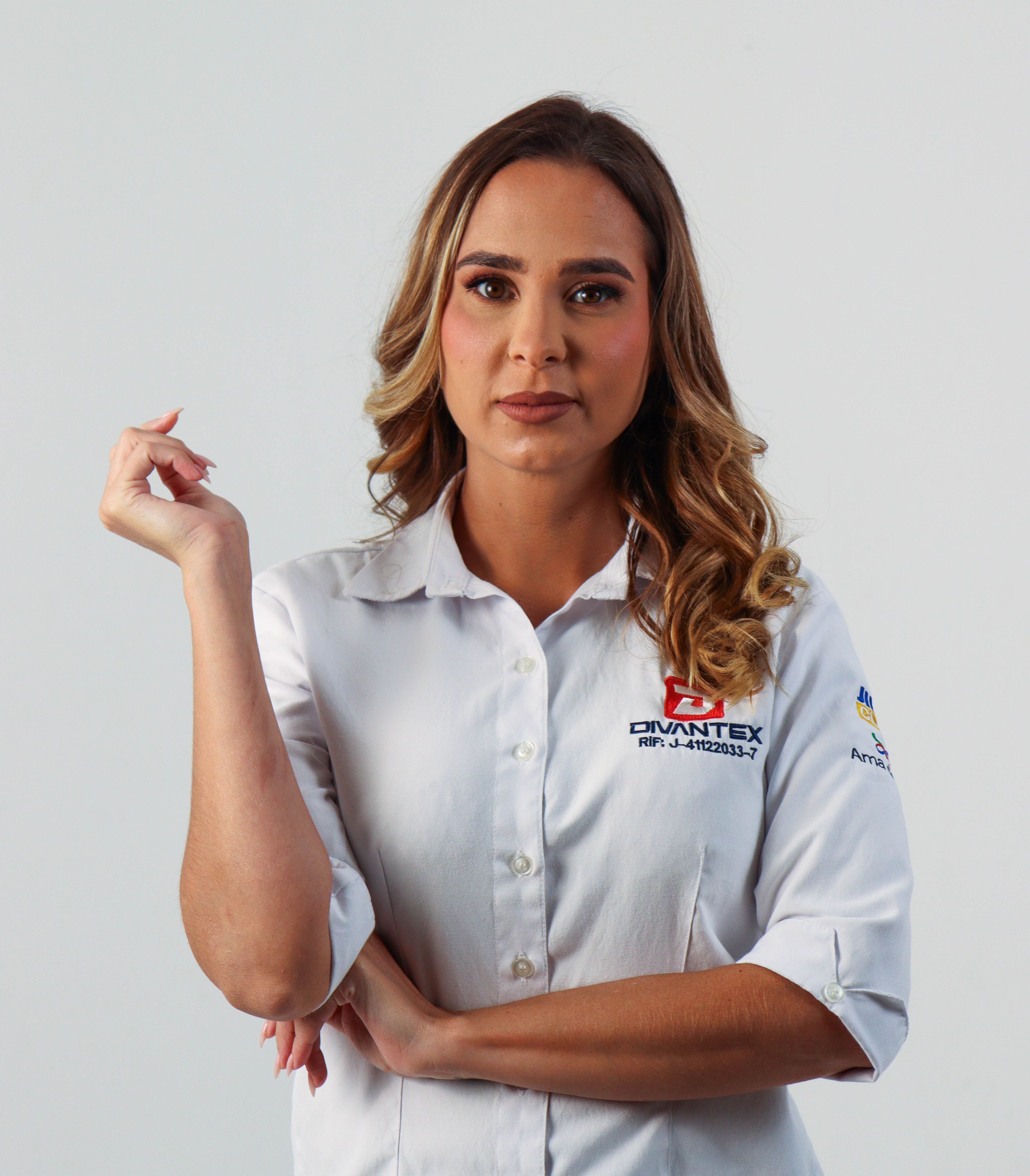 Confident woman posing in a branded shirt, exemplifying professional demeanor with neutral background.