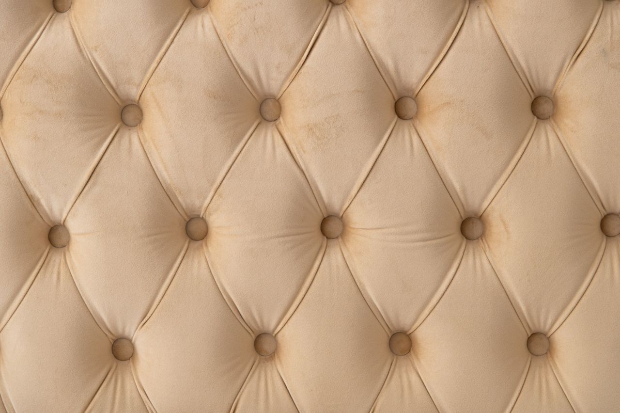 Close-up of beige tufted sofa upholstery fabric texture
