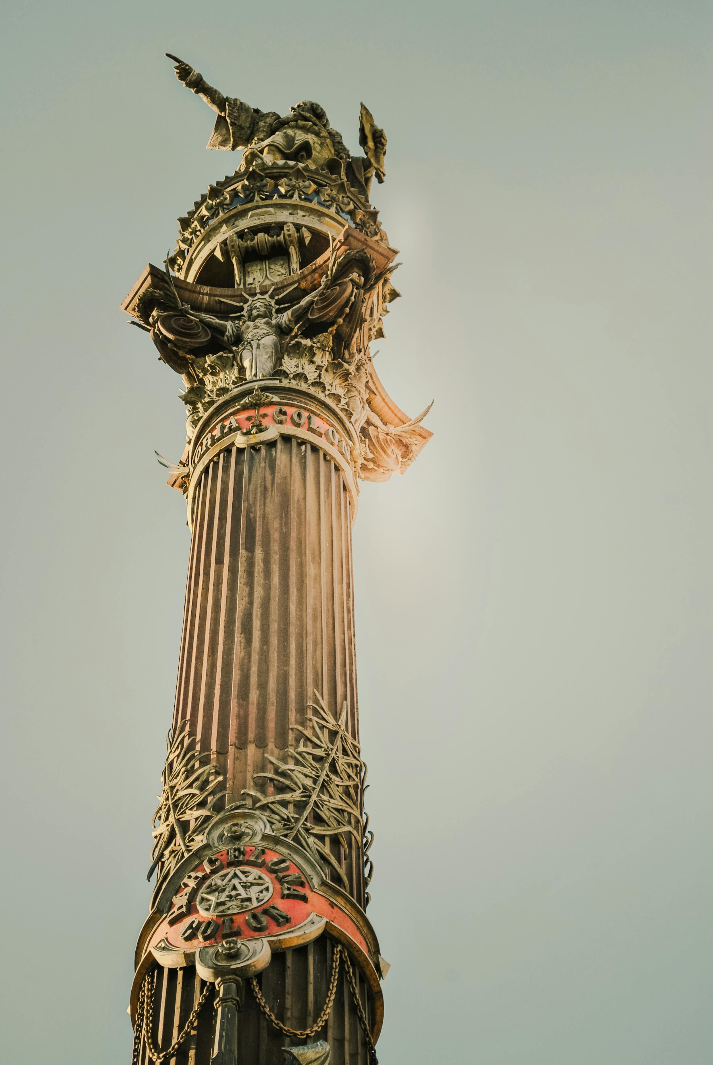 Stunning upward view of the Columbus Monument in Barcelona against a clear sky.