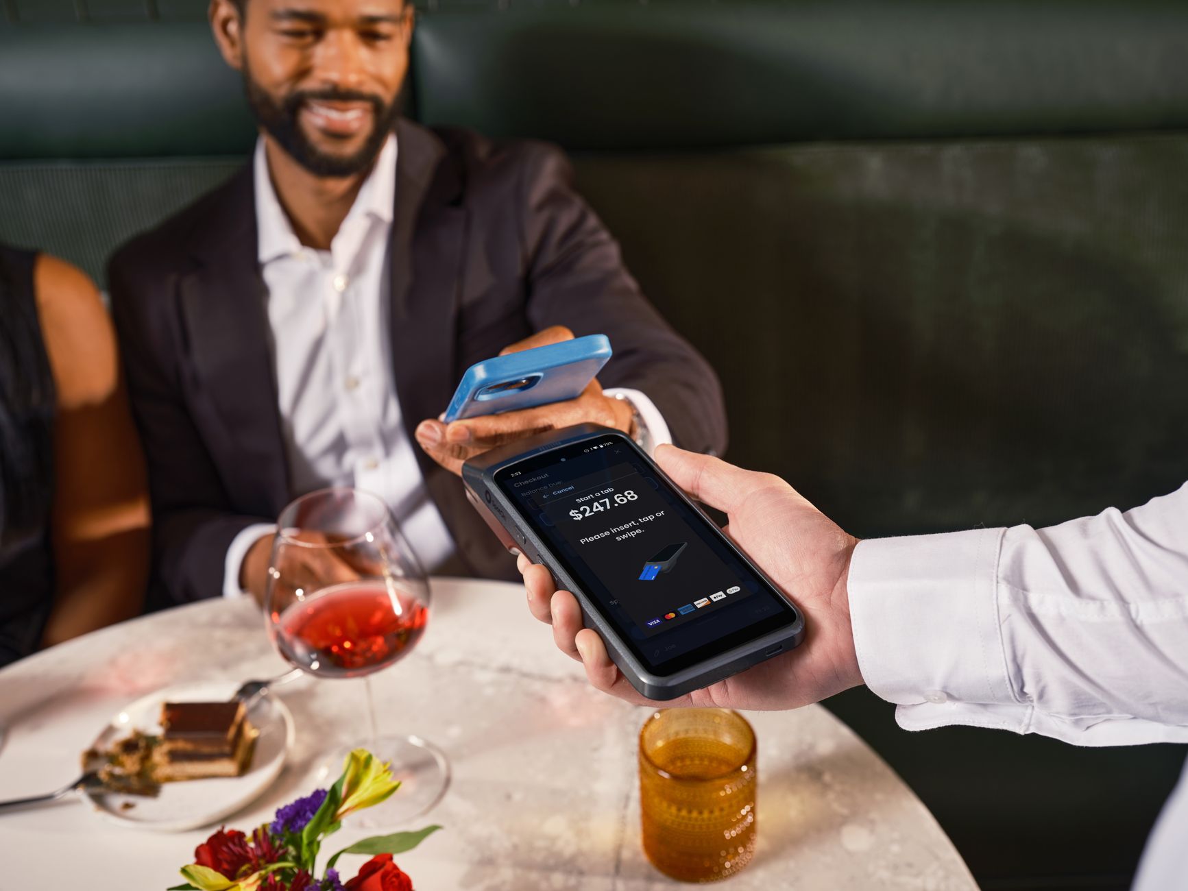 Contactless payment being made in a sophisticated restaurant setting, enhancing customer convenience.