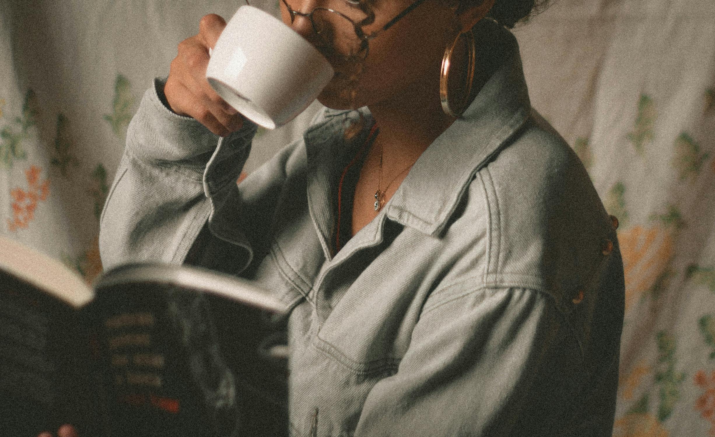 Image of woman drinking coffee in white ceramic mug