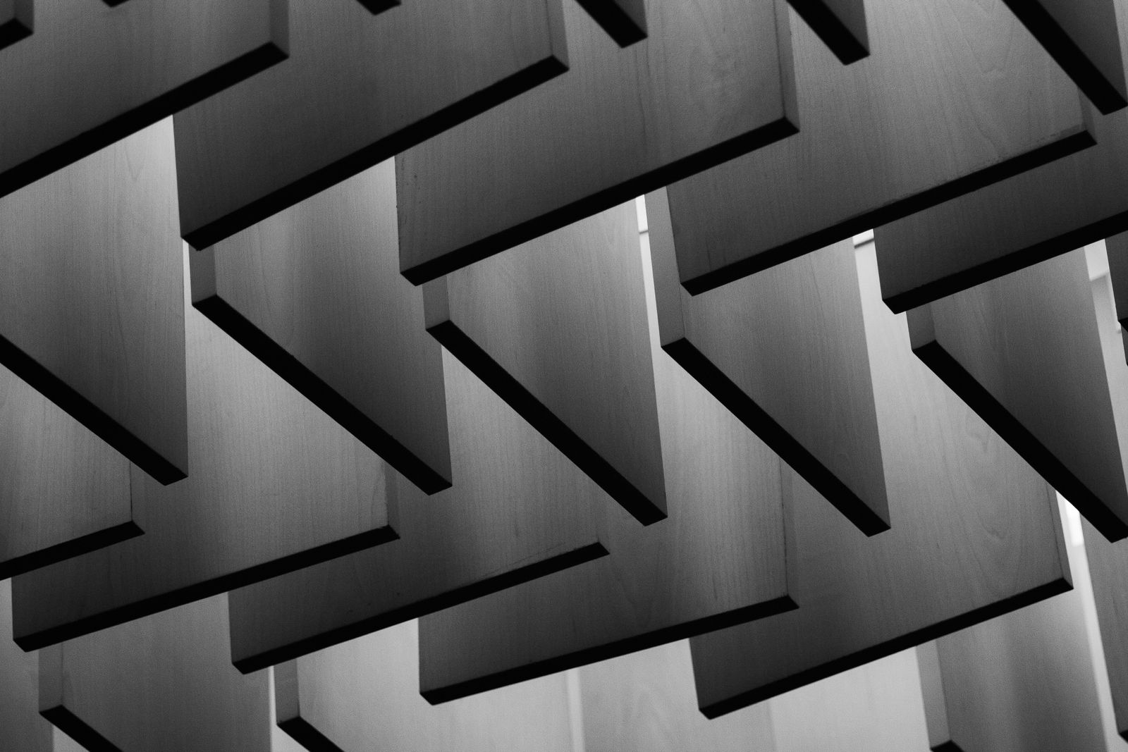 Geometric ceiling of angled timber panels.