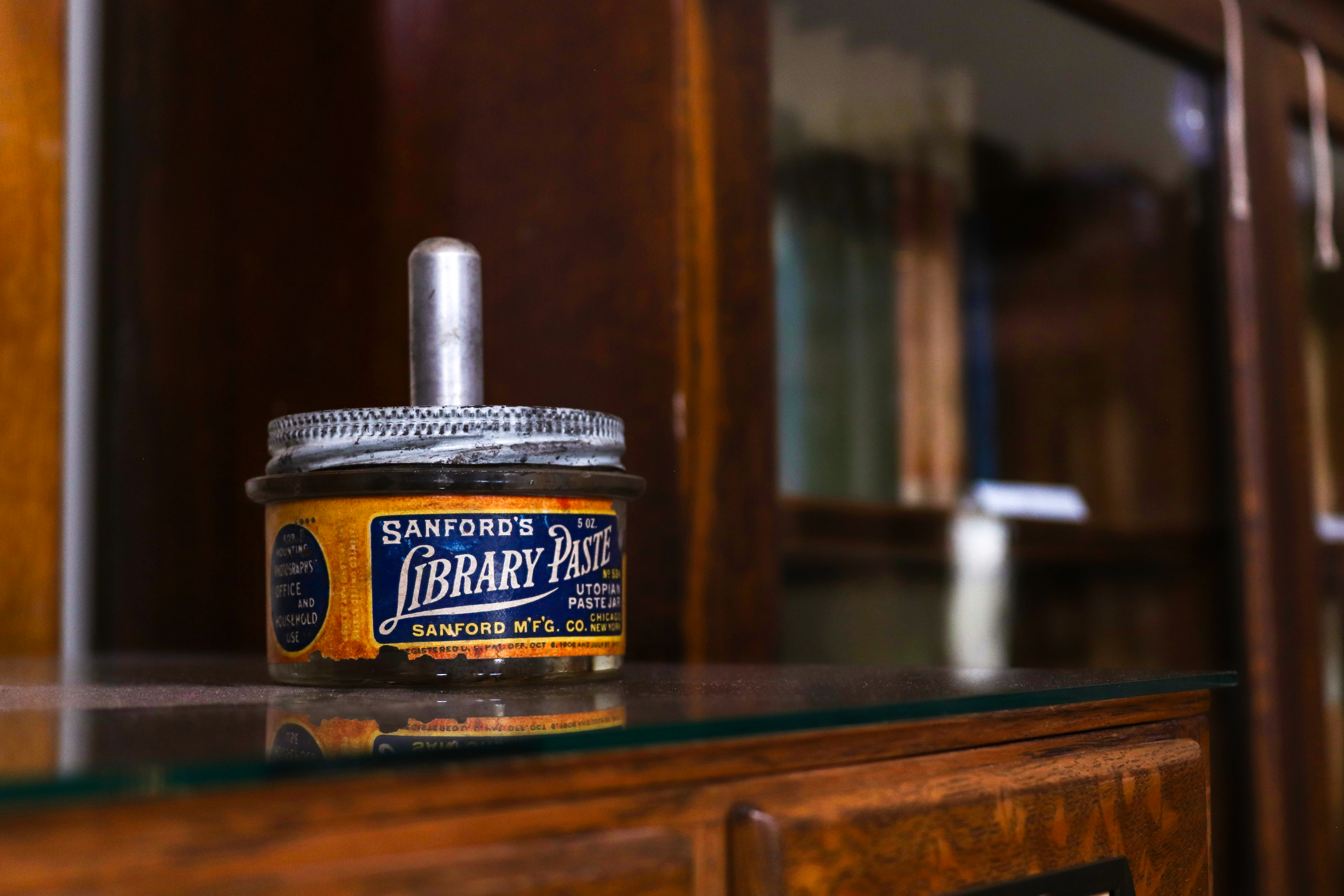 Vintage Sanford Library Paste Jar on Bookshelf · Free Stock Photo