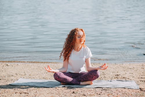 Gratis Mujer Haciendo Ejercicio De Yoga En La Orilla Del Mar Foto de stock