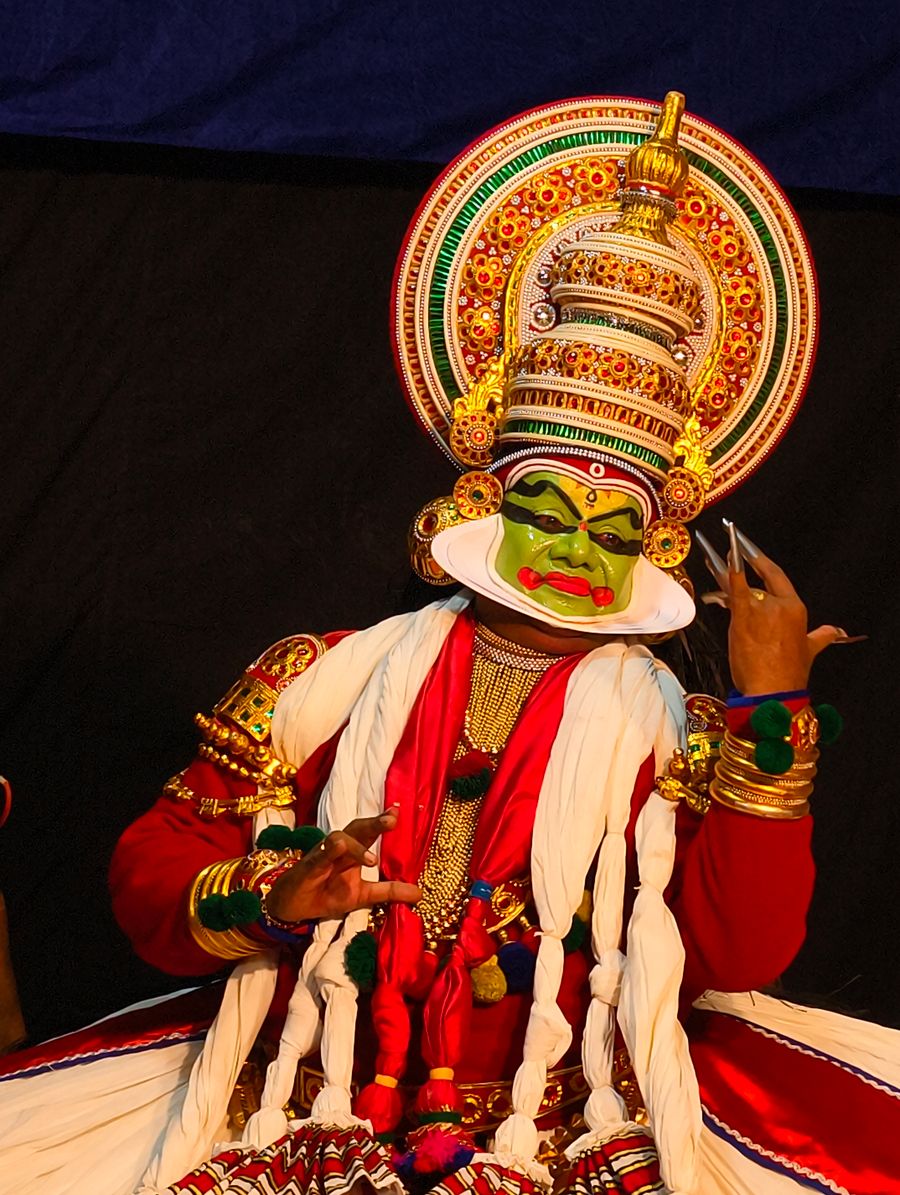 Kathakali performer in traditional makeup and costume on stage