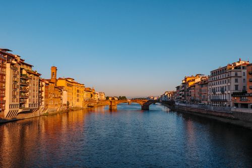 Gratuit Apus de soare uluitor peste râul Arno din Florența, evidențiind arhitectura istorică și reflecții senine. Fotografie de stoc