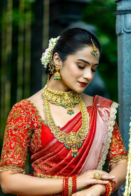 Free Stunning portrait of an Indian bride in red saree adorned with traditional jewelry. Stock Photo