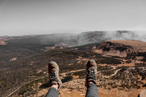 Crop hiker relaxing on mountain after achieving peak