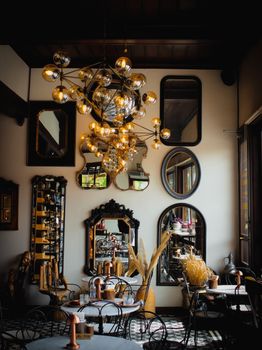 Elegant vintage-style cafe with ornate mirrors, chandeliers, and cozy seating.