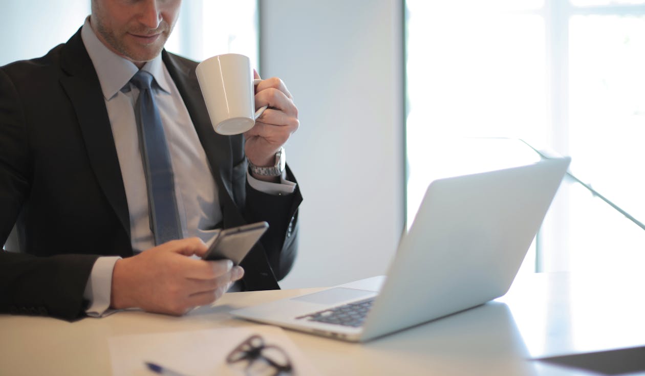 Free A Man In Black Suit Drinking Coffee During Daylight Stock Photo