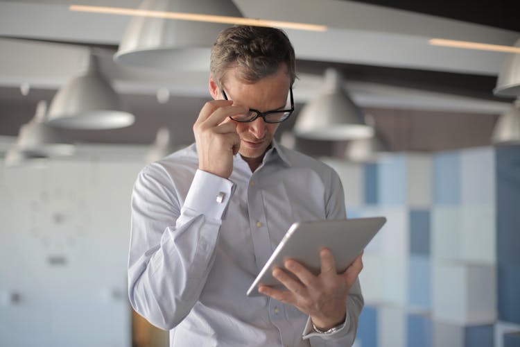 Man Reading An Article On Tablet