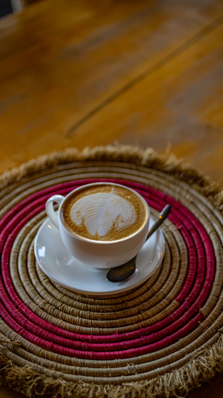Small woven jute mat placed under the base of a coffee bar hutch