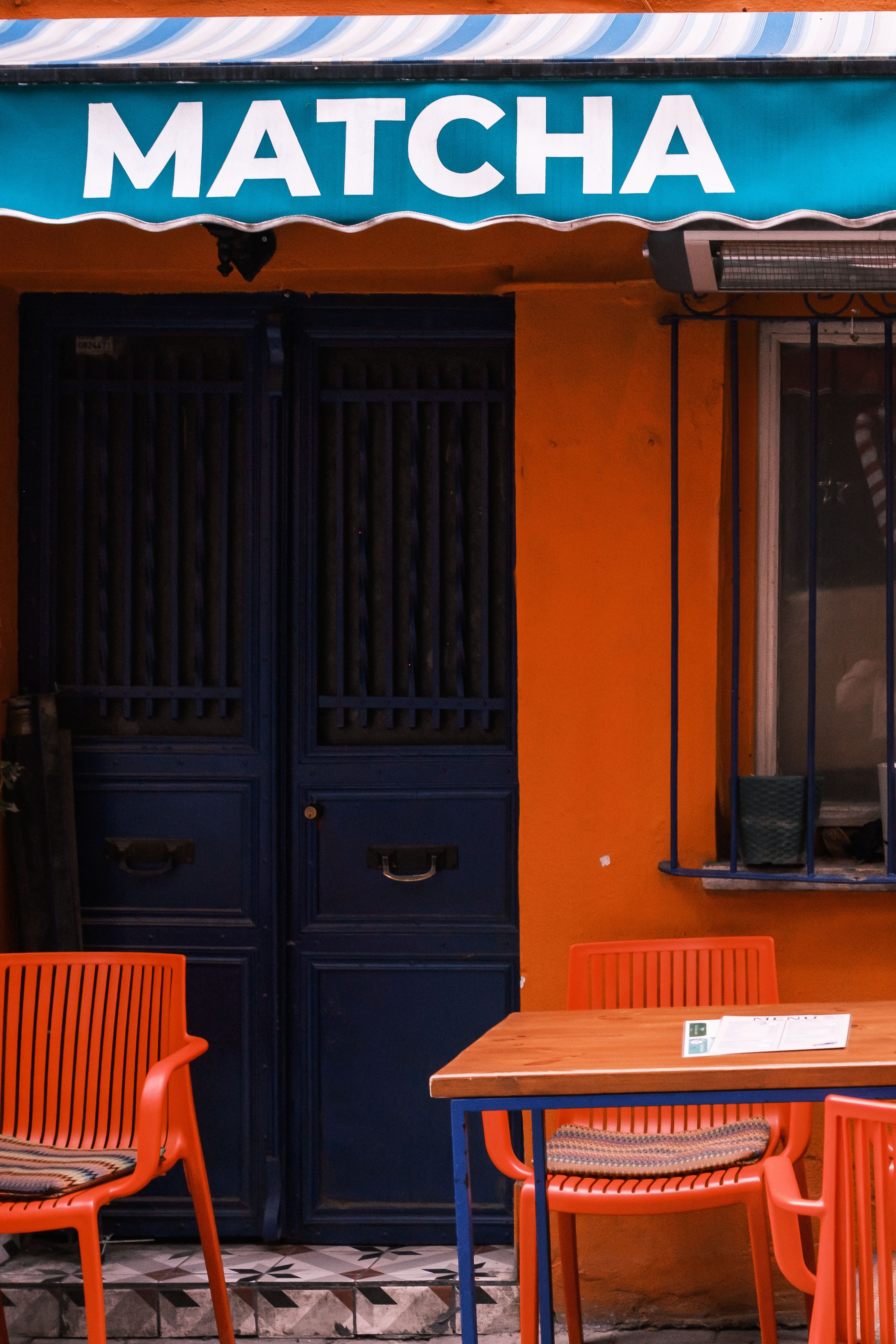 Vibrant Outdoor Café with Matcha Sign · Free Stock Photo