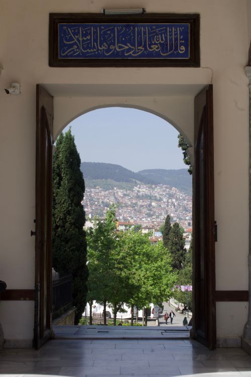 Free Scenic view of Bursa through a historic archway showcasing lush greenery and mountainous backdrop. Stock Photo