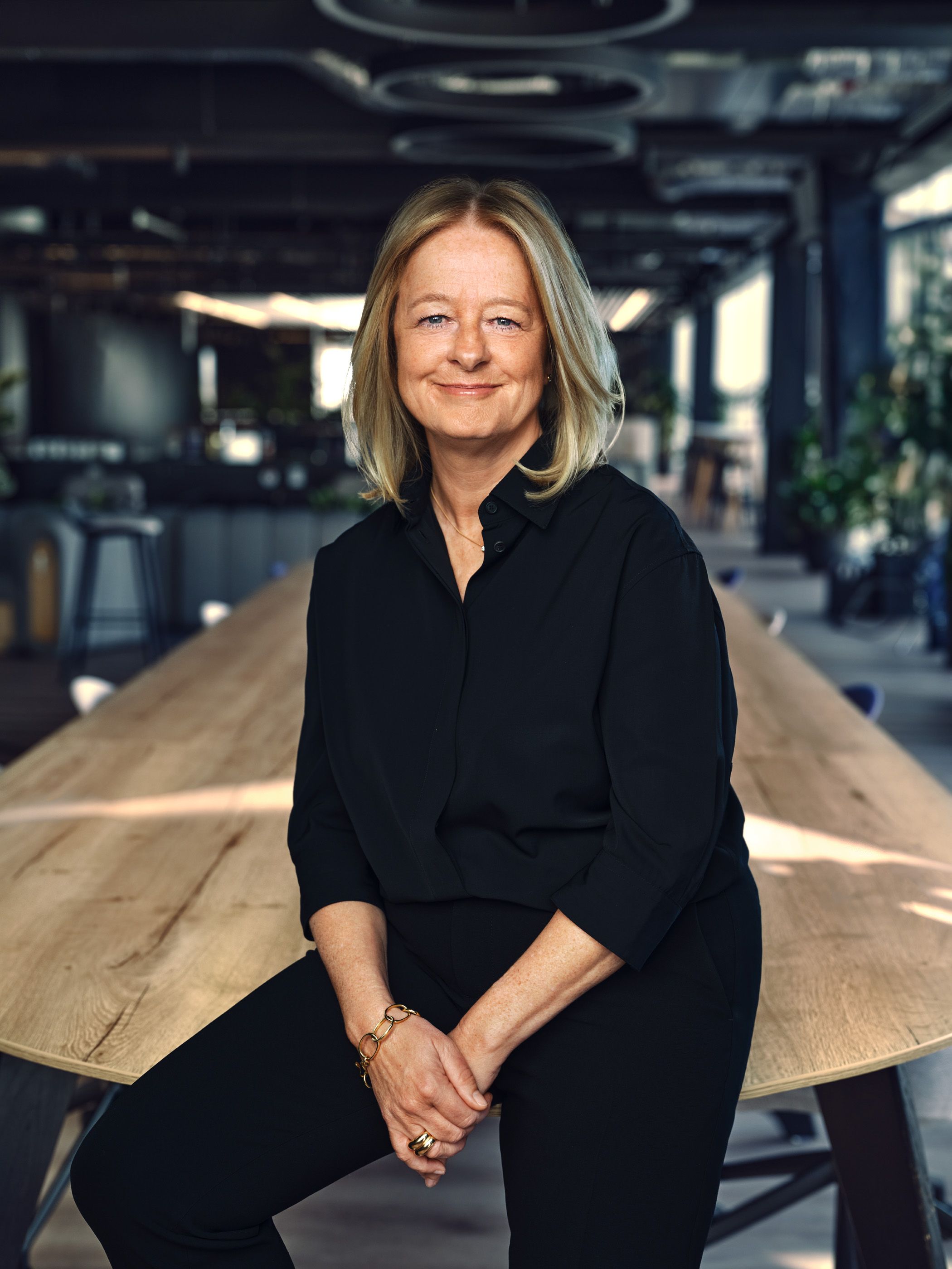Businesswoman seated in a modern office environment, exuding confidence and professionalism.