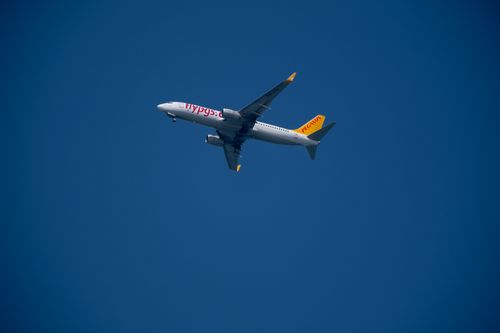 Free A Pegasus airplane soaring high above İzmir, Türkiye against a clear blue sky. Stock Photo