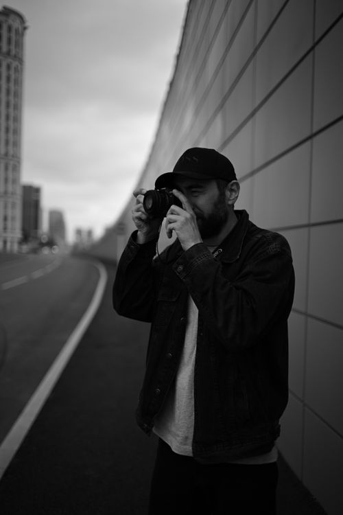 Free A street photographer takes a picture against the urban backdrop of Grozny, Russia. Stock Photo