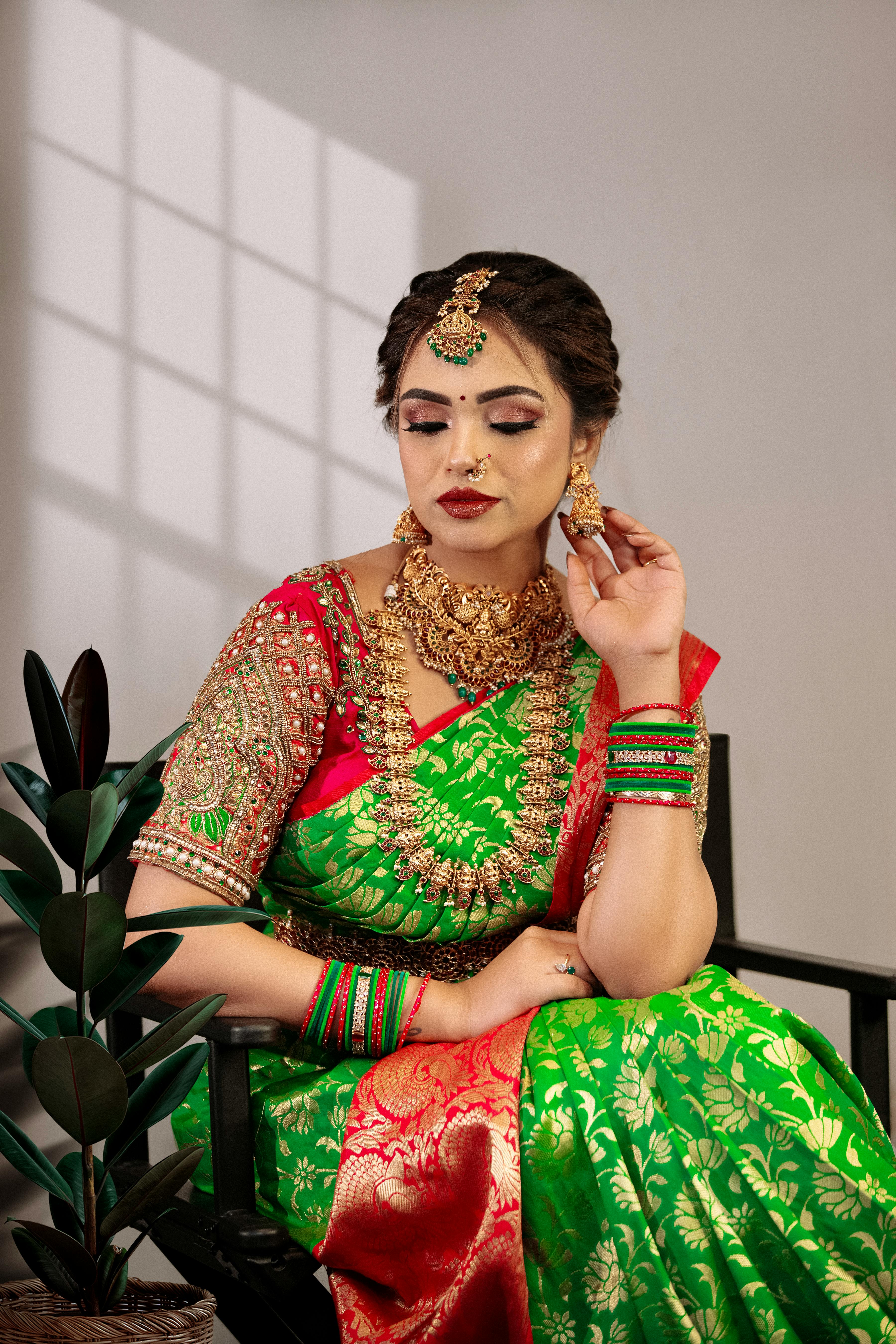 Beautiful Indian bride in a green and red saree with gold jewelry, shot in Hyderabad.