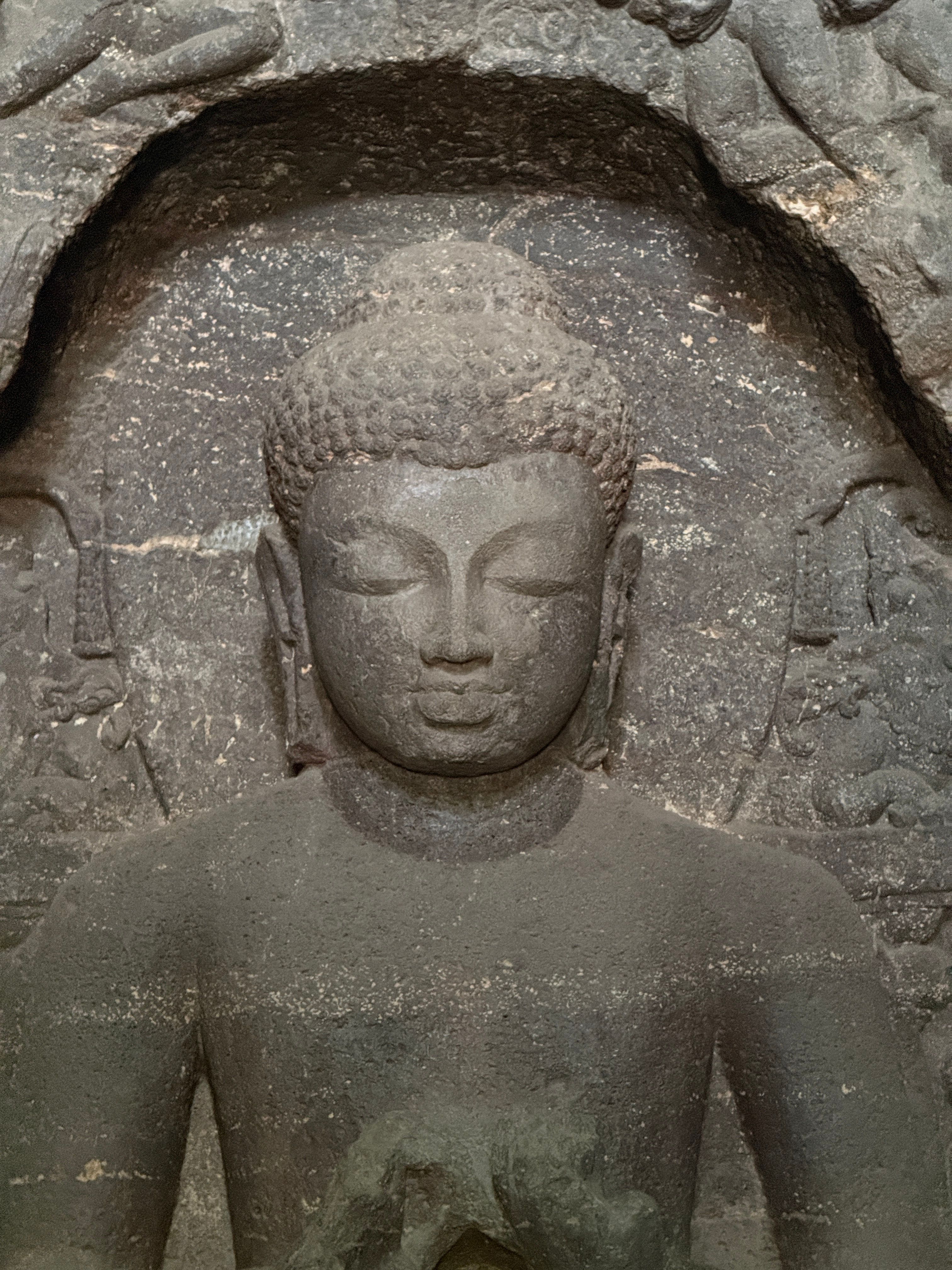 Close-up of an ancient Buddha stone carving with serene expression.