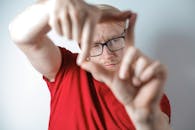 一个戴眼镜的男人用手框住脸，展现创造力